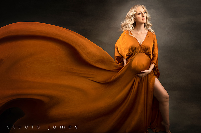 edited image of maternity photography in calgary. Pregnant woman wearing cognac gown.