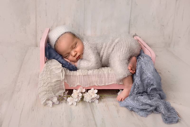 finished image of newborn baby asleep in bed prop in newborn photography session in calgary alberta