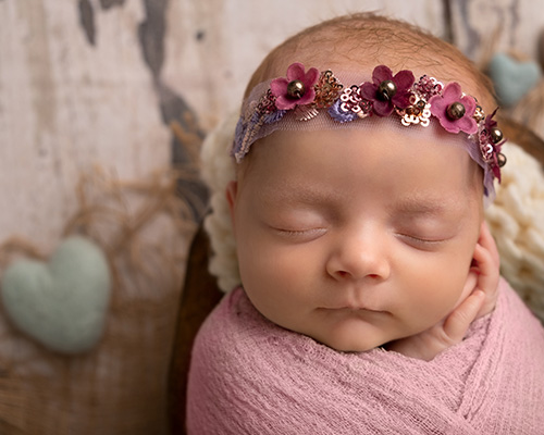newborn girl wrapped in pink by felt hearts in calgary