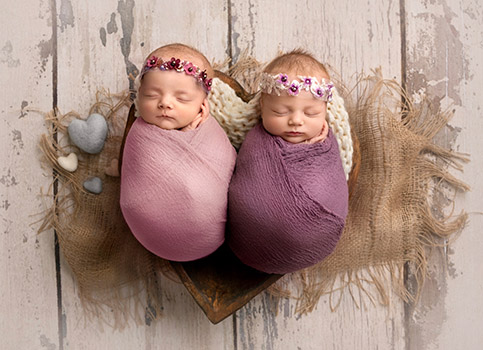 picture of twin newborn girls in a heart bowl in photography session calgary