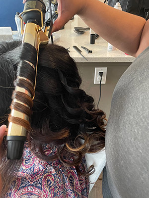 maternity client in calgary getting her hair curled by a professional hair and makeup artist