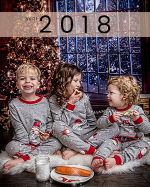 3 kids laughing and eating cookies at holiday photo session at Studio James in Calgary