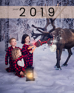 3 kids feeding a reindeer a carrot at holiday session in Calgary at Studio James